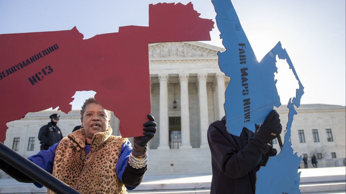 Activists opposed to partisan gerrymandering hold up representations of congressional districts at the Supreme Court in Washington on March 26.