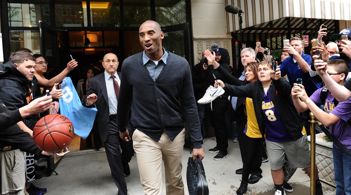 Lakers Kobe Bryant leaves the Skirvin Hilton as fans take photographs and seek autograpghs beofre boarding the bus in Oklahoma City on Monday.