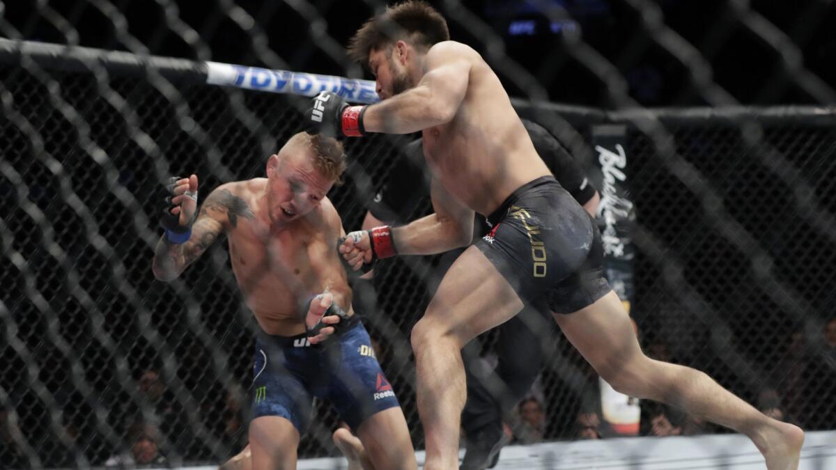 Henry Cejudo, right, punches T.J. Dillashaw during the first round of a flyweight mixed martial arts championship bout at UFC Fight Night.