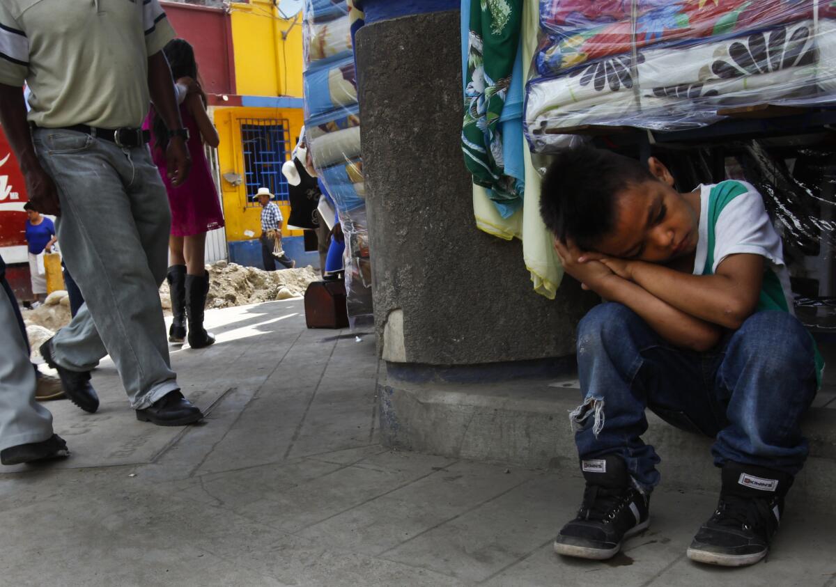 Anderson Daniel, 7, from Honduras, sits exhausted on a hot street in the southern Mexican city of Tapachula. Migrants, including minors, pass through on their way to the United States. Many never make it and are either deported or end up staying on in Mexico's poorest state.