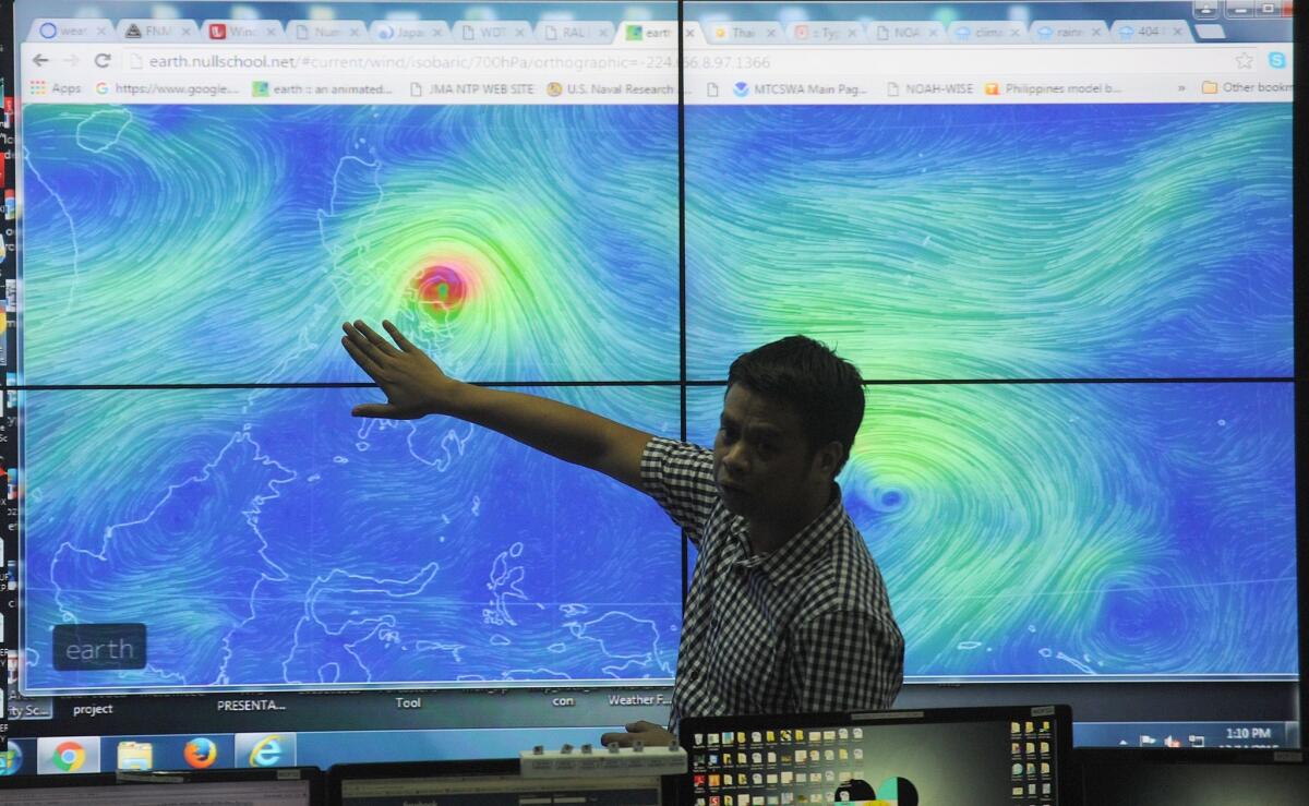 Meteorologists from the Philippine Atmospheric Geophysical and Astronomical Services Administration monitor and plot the direction of Typhoon Melor at their headquarters in suburban Manila on Dec. 14.