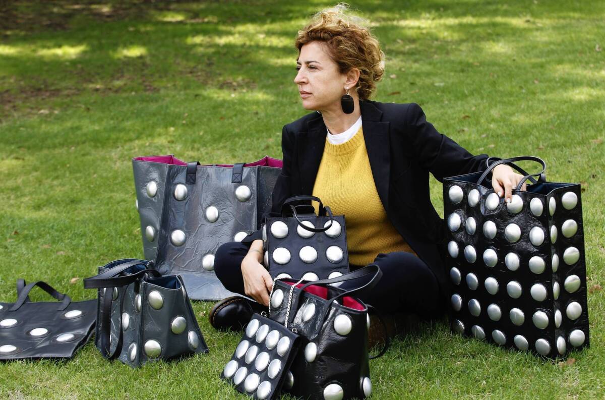 Ilaria Venturini Fendi with bags from her Carmina Campus fashion project that produces bags from repurposed materials in Dallas.