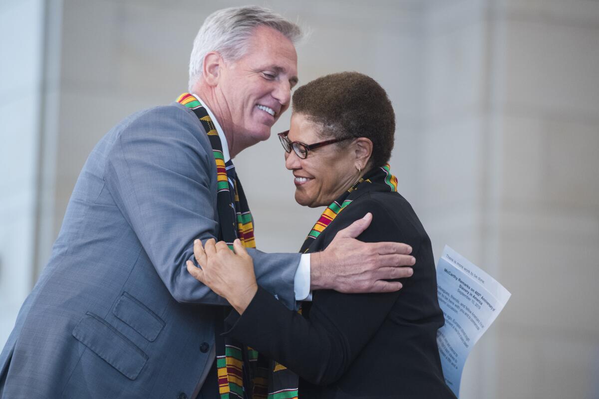 House Minority Leader Kevin McCarthy and Rep. Karen Bass embrace in the Capitol's Emancipation Hall in Washington in 2019.