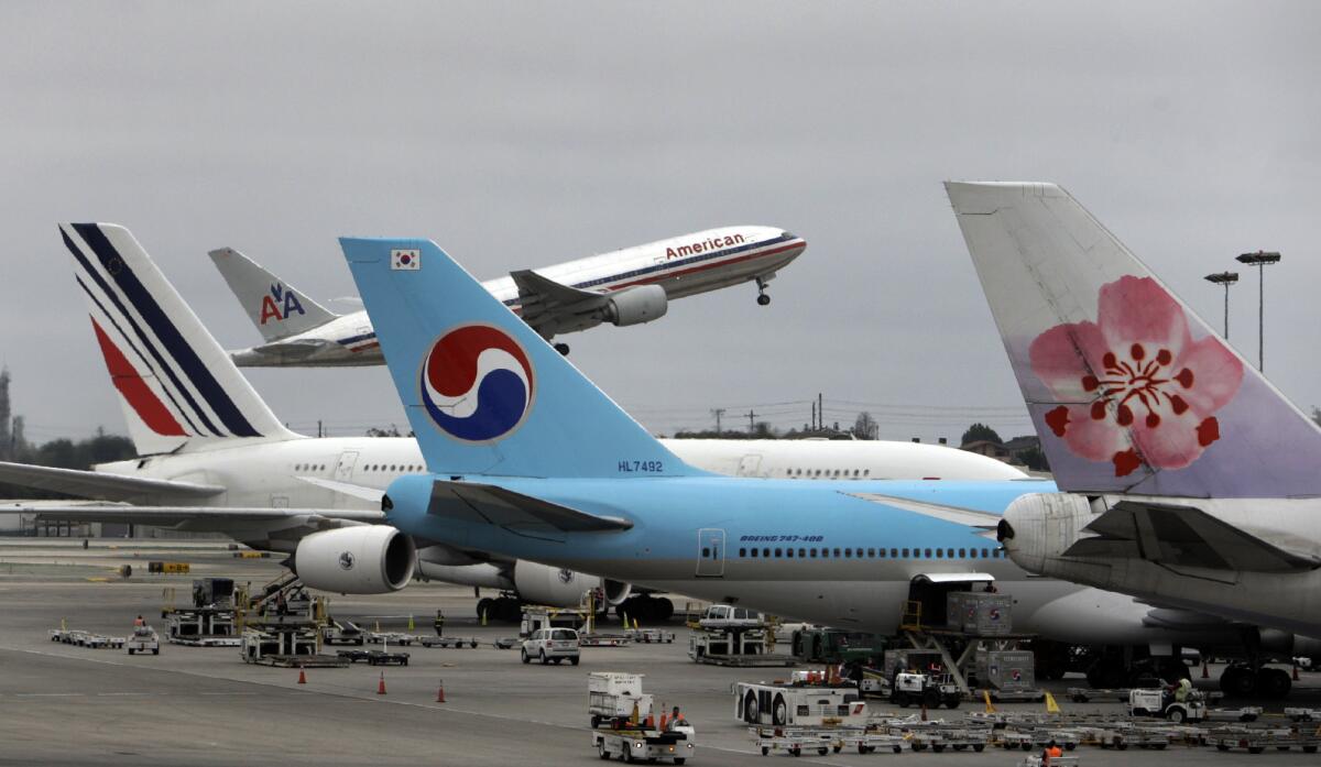 Tugs and baggage trucks line the ramp area outide one of the passenger terminals at Los Angeles International Airport. Cal/OSHA is now investigating the Feb. 21 death of a baggage handler who was working in the ramp area.