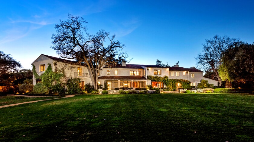 A mansion is surrounded by sprawling lawns.