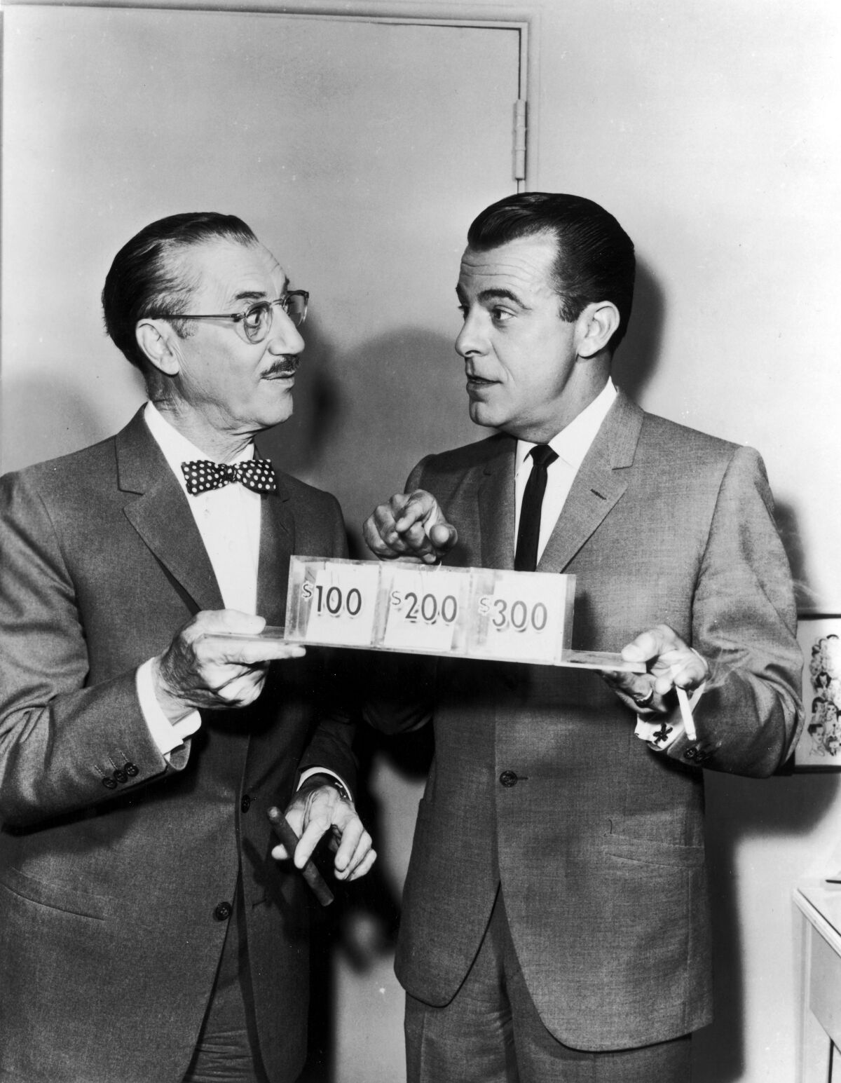 American comedian Groucho Marx with his co-host on the radio and television quiz show 'You Bet Your Life', George Fenneman