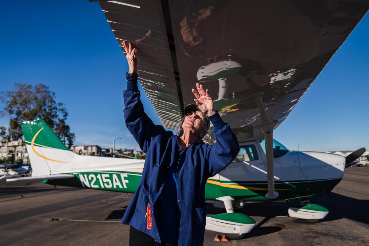 Ann Rothwell, 75, does a preflight check of the Cessna 172 plane she flies at Montgomery-Gibbs Executive Airport. 