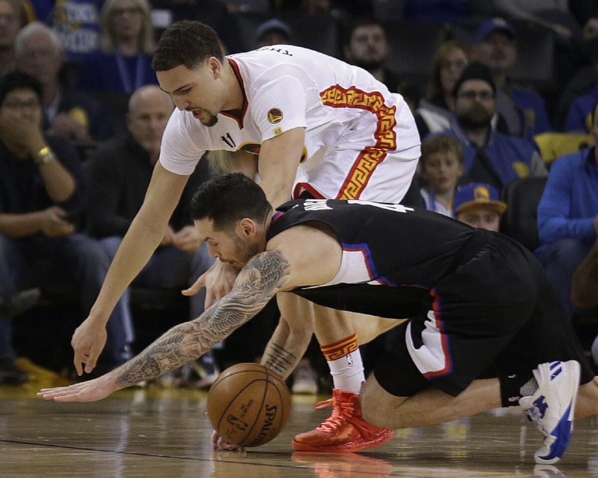 Clippers guard J.J. Redick, bottom, and Warriors guard Klay Thompson fight for the ball during the first half on Jan. 28.