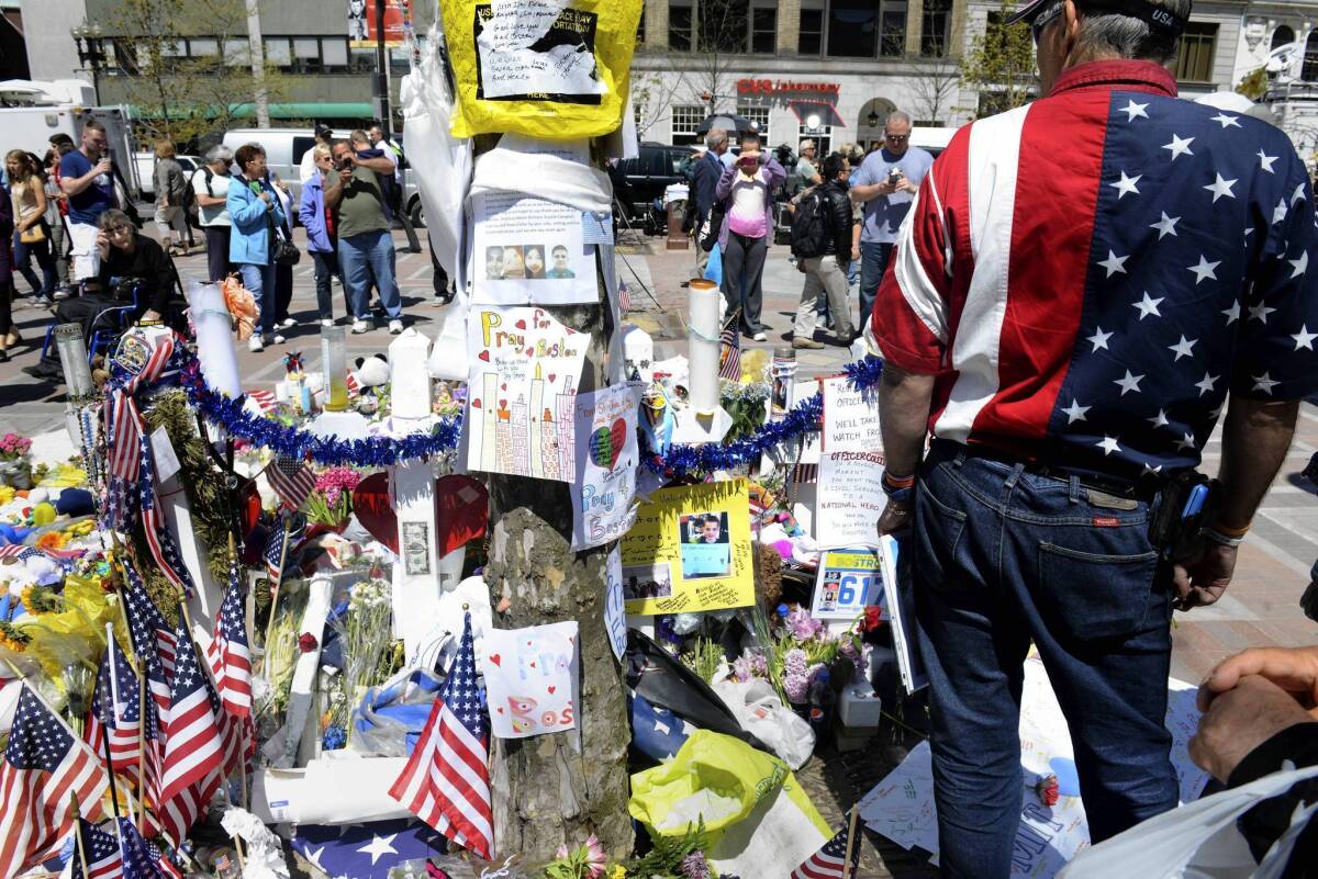 Visitors stop by the makeshift memorial in Copley Square dedicated to the victims of the Boston Marathon bombings.