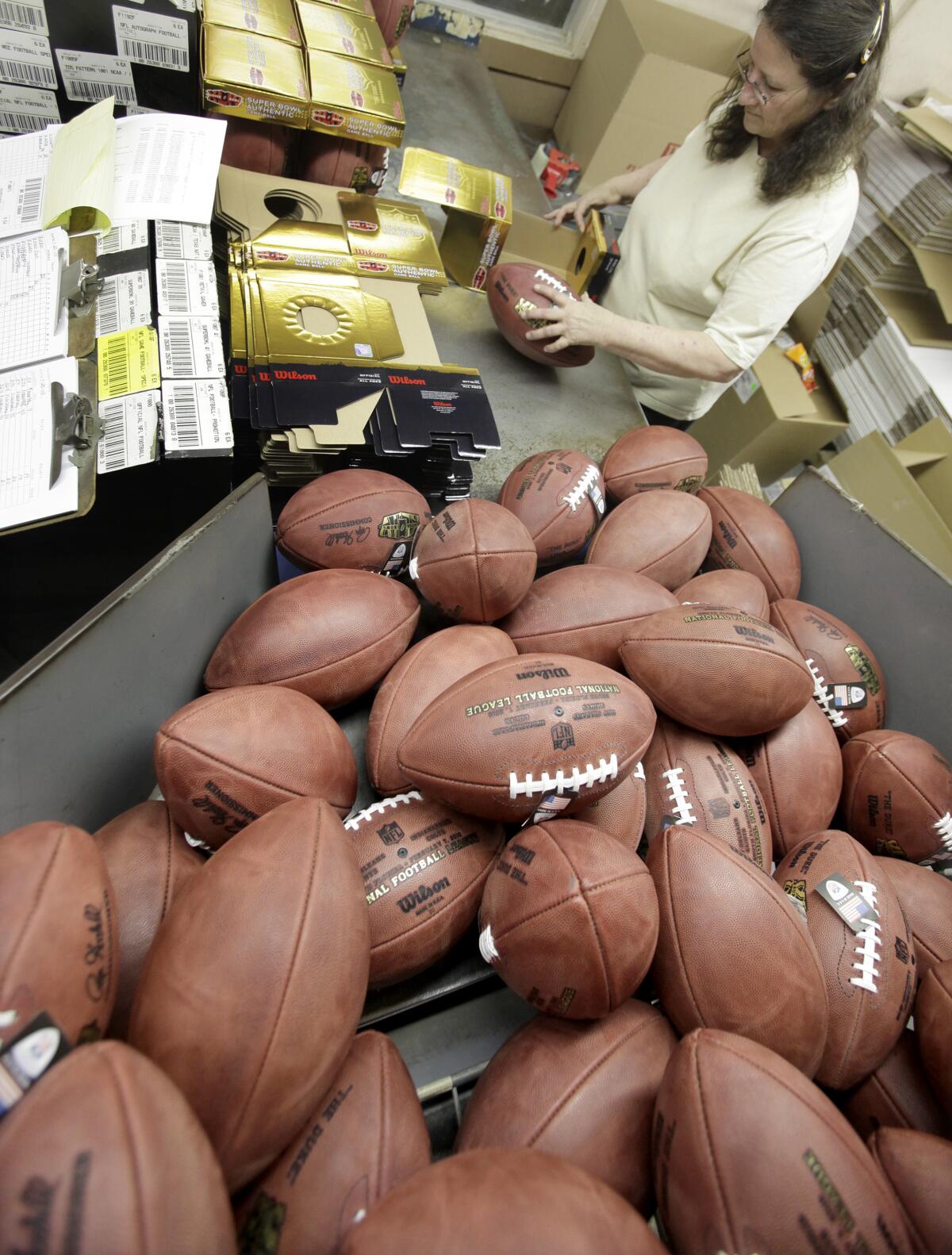 Lora Shadley packs footballs for retail sale at the Wilson Sporting Goods football factory in Ada, Ohio, which is near Toledo