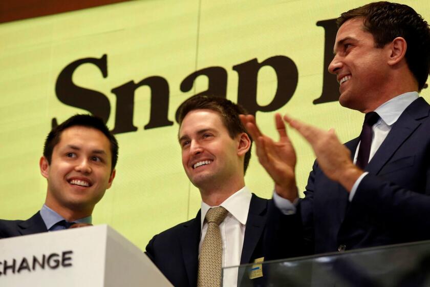 NEW YORK, NEW YORK--MARCH 2, 2017--Snap Inc. will make it's debut on the New York Stock Exchange on March 2, 2017. CEO Evan Spiegel, center, rings the bell at the NYSE for its debut, along with colleague Bobby Murphy, left, and NYSE President Thomas Farley, right. Snap Inc. is the parent company of Snapchat. (Carolyn Cole/Los Angeles Times)