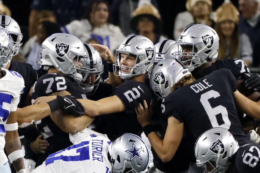 Las Vegas Raiders place kicker Daniel Carlson (2) is congratulated by Jermaine Eluemunor (72), AJ Cole (6) and others after Carlson kicked a game-winning field goal in overtime of an NFL football game against the Dallas Cowboys in Arlington, Texas, Thursday, Nov. 25, 2021. (AP Photo/Ron Jenkins)