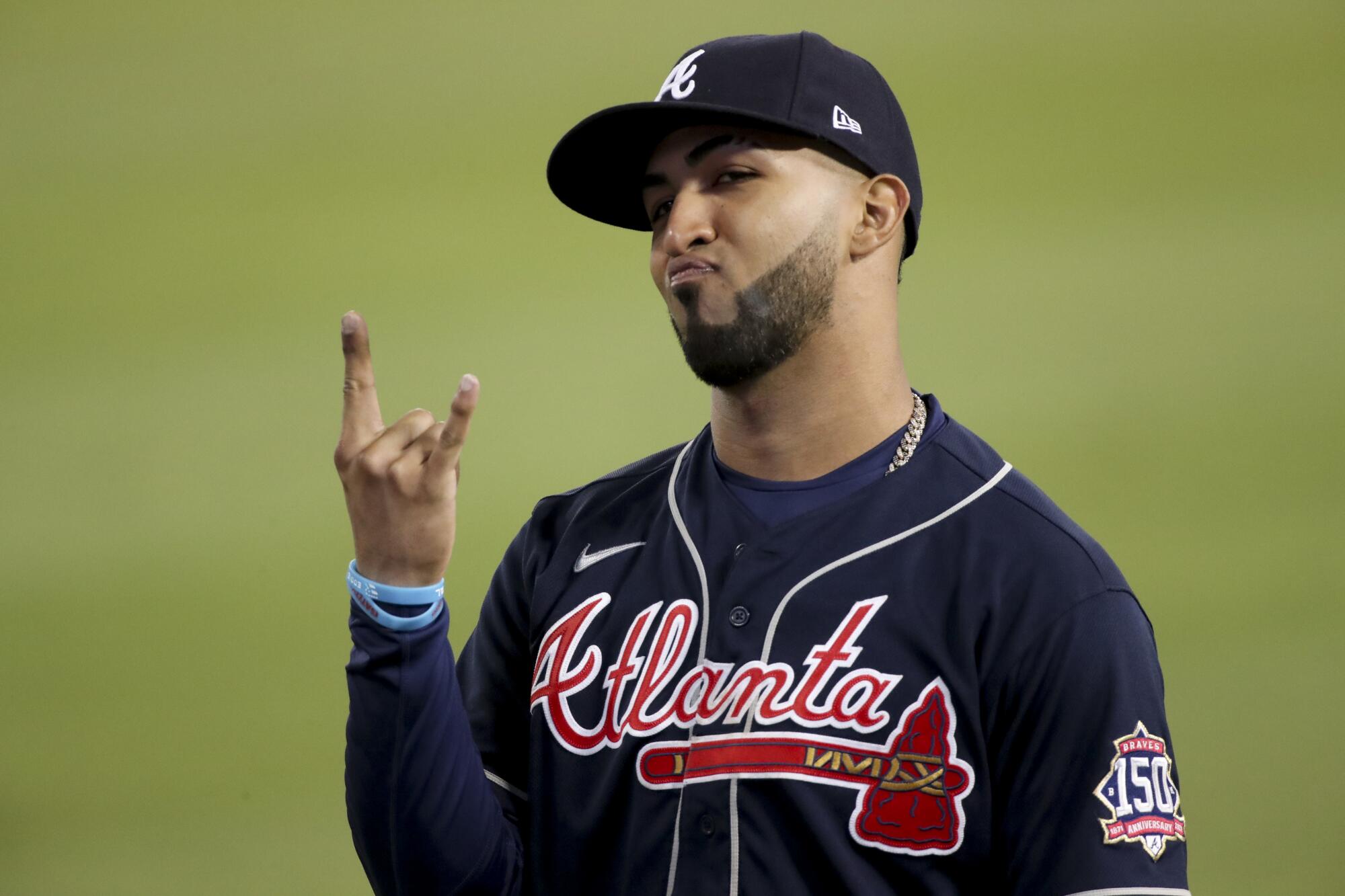 Braves' Eddie Rosario gestures to the fans during the ninth inning.