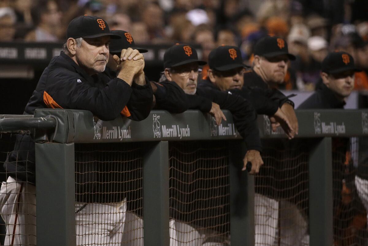 San Francisco Manager Bruce Bochy, left, watches with others from the Giants dugout during an 8-5 loss to the Chicago Cubs on Tuesday.