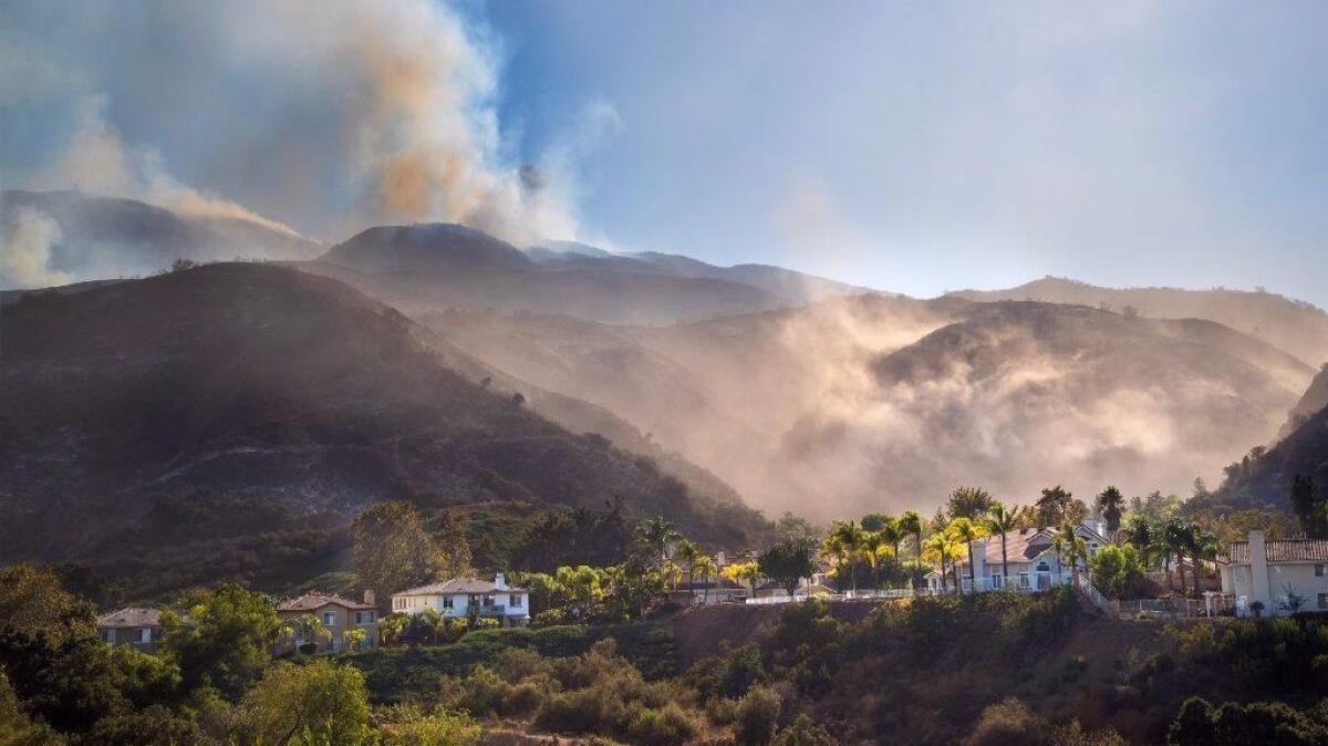 Firefighters declared the Canyon fire 95% contained Monday morning. The week-old fire, seen here burning above homes on the south side of the 91 Freeway, forced the evacuation of as many as 1,500 residents.