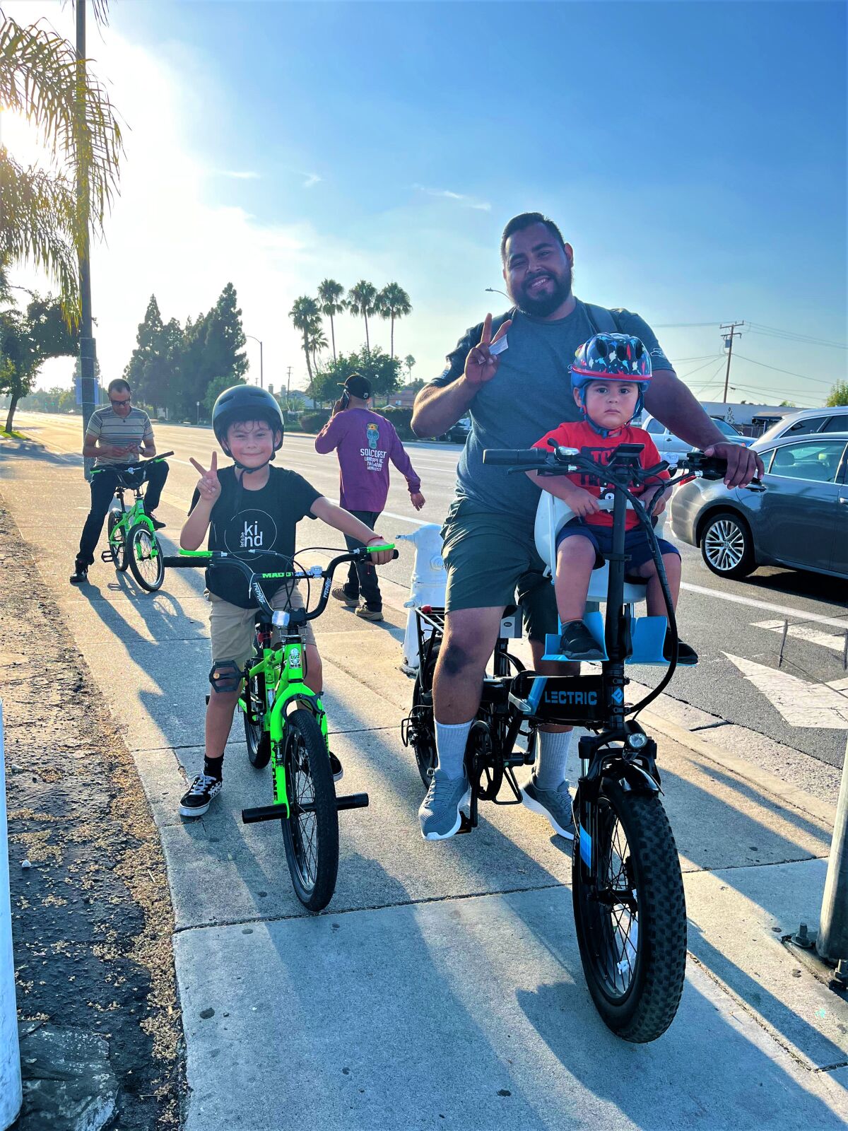 A family rides during a free bicycle light giveaway last fall in Costa Mesa, where officials have embraced bike safety.