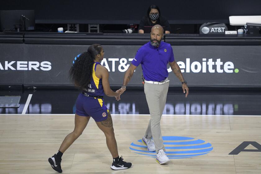 Los Angeles Sparks head coach Derek Fisher, right, greets guard Te'a Cooper during a timeout in the first half of a WNBA basketball game against the Indiana Fever, Saturday, Aug. 15, 2020, in Bradenton, Fla. (AP Photo/Phelan M. Ebenhack)