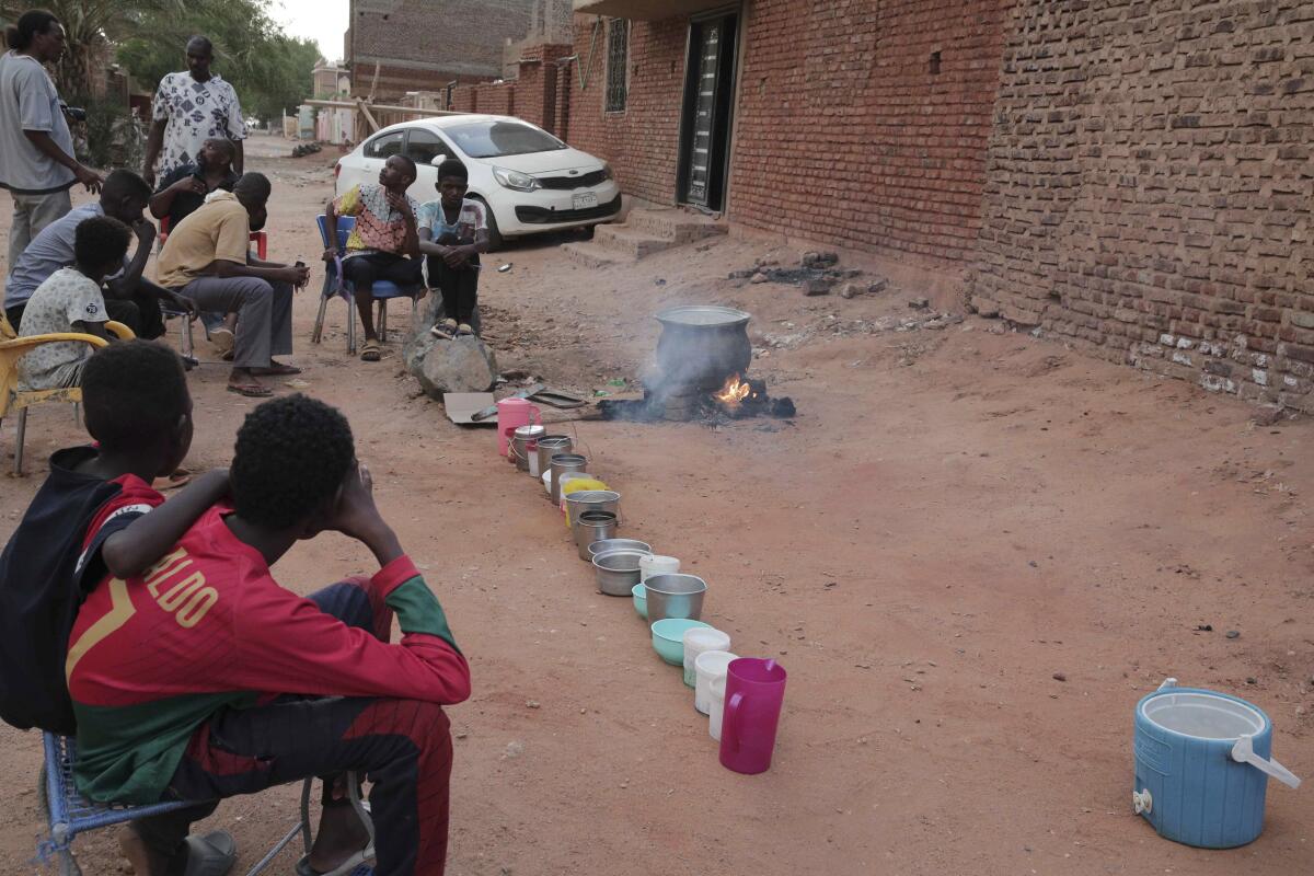 People prepare food outdoors in a Khartoum, Sudan, neighborhood.