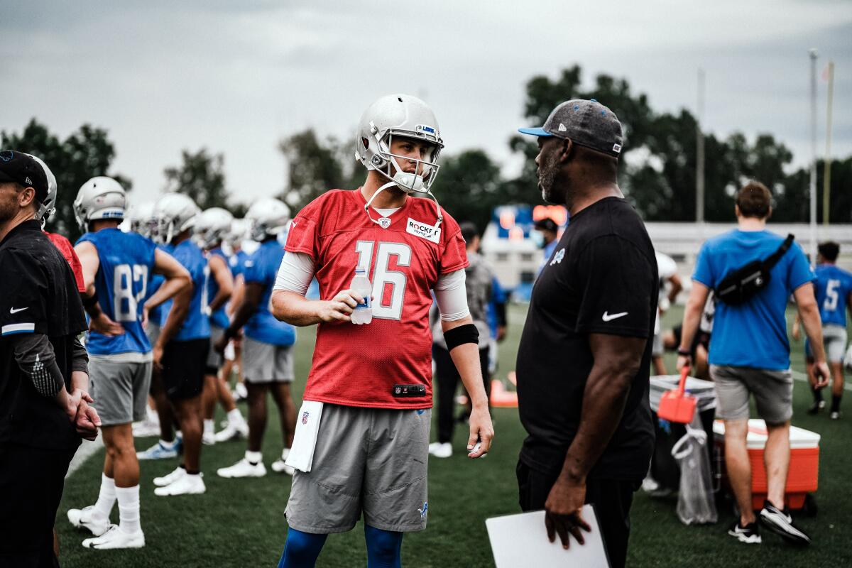 Jared Goff talks to Anthony Lynn on the football field.