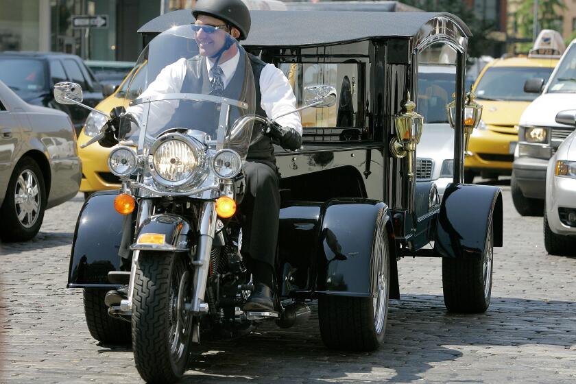 FILE - Peter Moloney, of Moloney Family Funeral Homes in Lake Ronkonkoma, N.Y., rides his Harley Davidson hearse from the Tombstone Hearse Co. of Alum Bank, Pa., in New York, May 24, 2007. (AP Photo/Richard Drew, File)