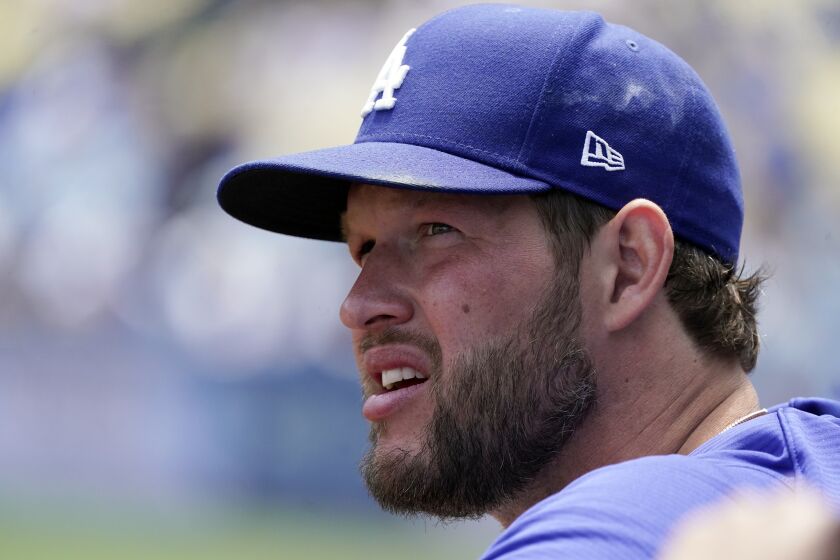 Los Angeles Dodgers starting pitcher Clayton Kershaw watches from the dugout.