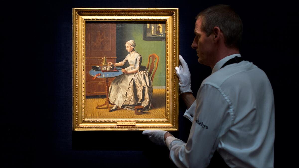 A technician adjusts "A Dutch Girl at Breakfast" by Jean-Etienne Liotard at Sotheby's London in July.
