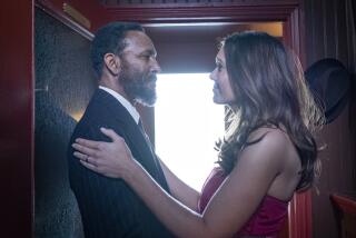 Mandy Moore embracing Ron Cephas Jones in formal attire in a train compartment.