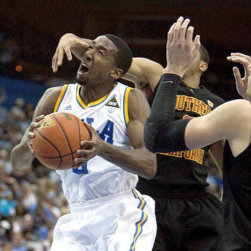 Bruins guard Malcolm Lee protects the ball, but not his head, from the swipe of Trojans guard Jio Fontan in the first half Wednesday night at Pauley Pavilion.