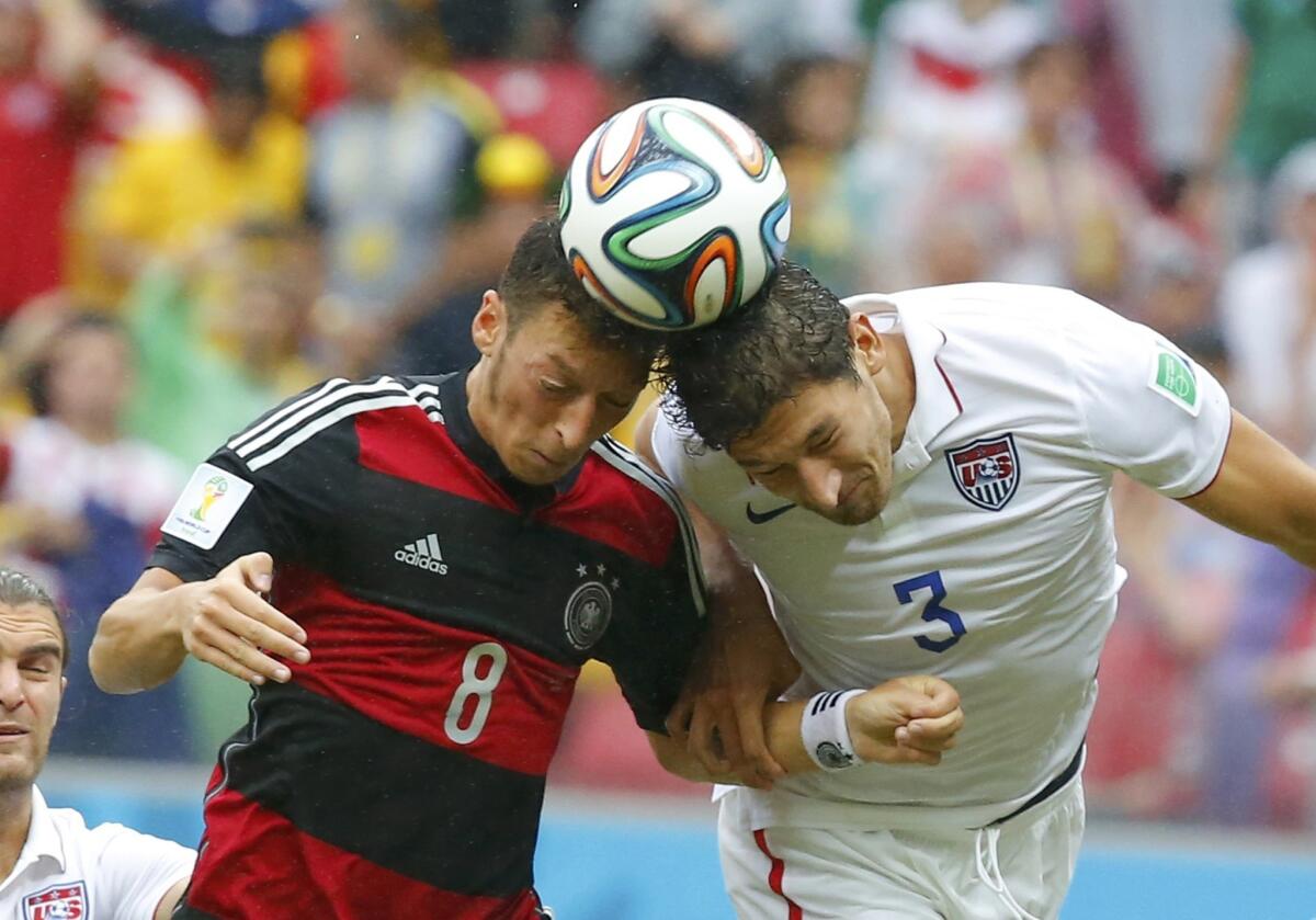 Germany's Mesut Ozil fights for the ball with Omar Gonzalez during their 2014 World Cup Group G soccer match.
