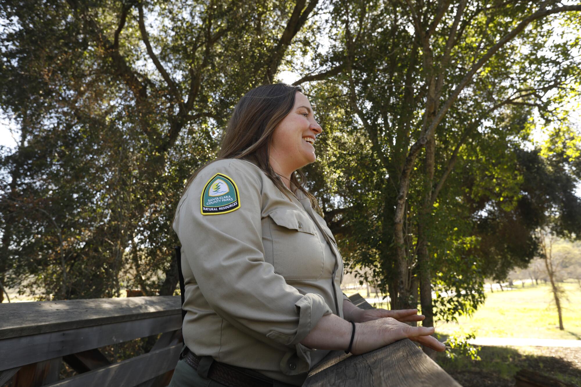 A woman in a uniform smiles outside