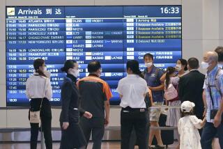 People wearing face masks are seen at an arrival lobby of Haneda airport in Tokyo on Aug. 23, 2022, amid the coronavirus pandemic. Japan’s Prime Minister Fumio Kishida on Wednesday announced plans to ease border controls from early September by eliminating requirements for pre-departure COVID-19 tests for travelers who have received at least three vaccine doses, and he will also consider increasing daily entry caps as soon as next month. (Kyodo News via AP)