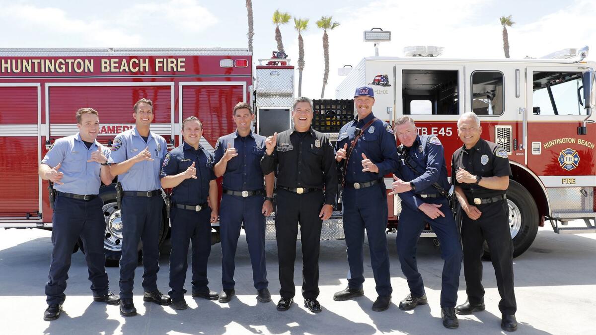 Huntington Beach Fire Chief David Segura, center, jokes with members of his team during a group portrait.