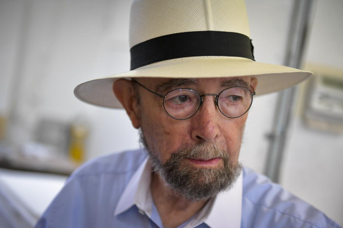 Sidney B. Felsen, in a wide-brimmed straw Panama hat and wire-rimmed glasses, looks to the side.