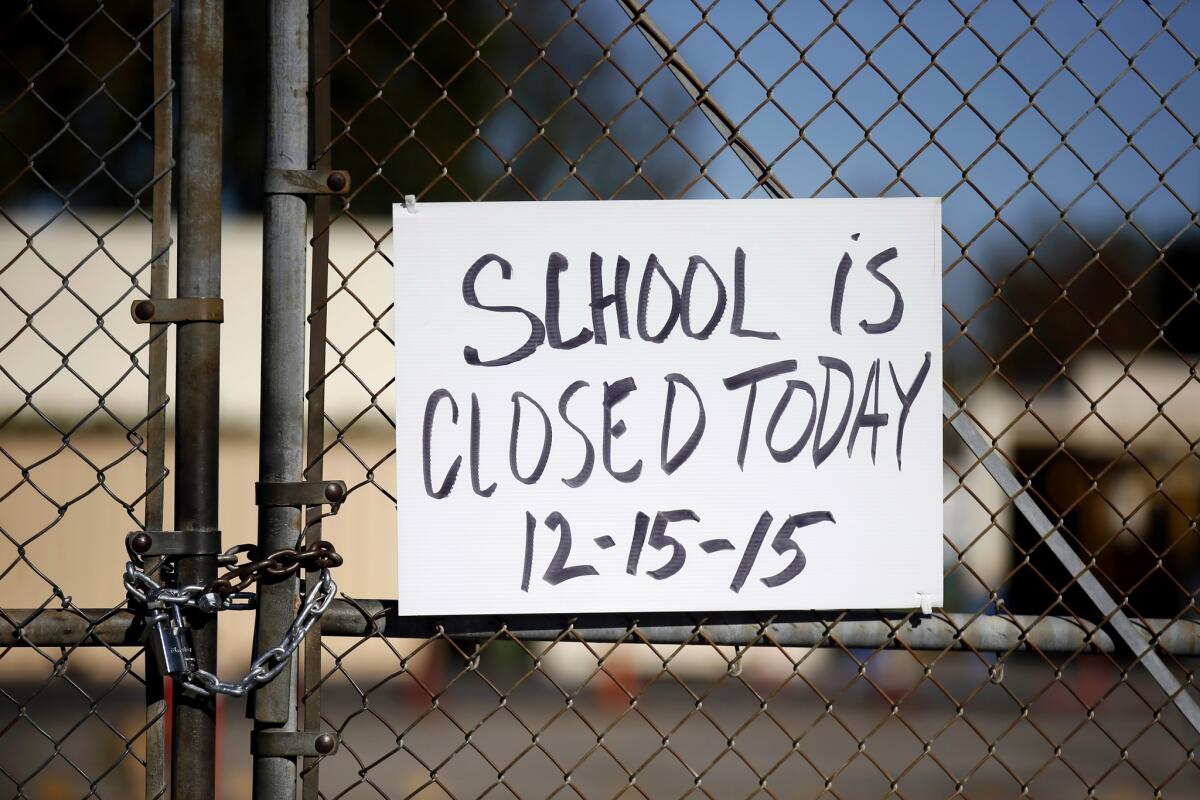 A gate to Birmingham Community Charter High School in the adjacent neighborhood of Lake Balboa is locked with a sign stating that school is closed on Dec. 15.