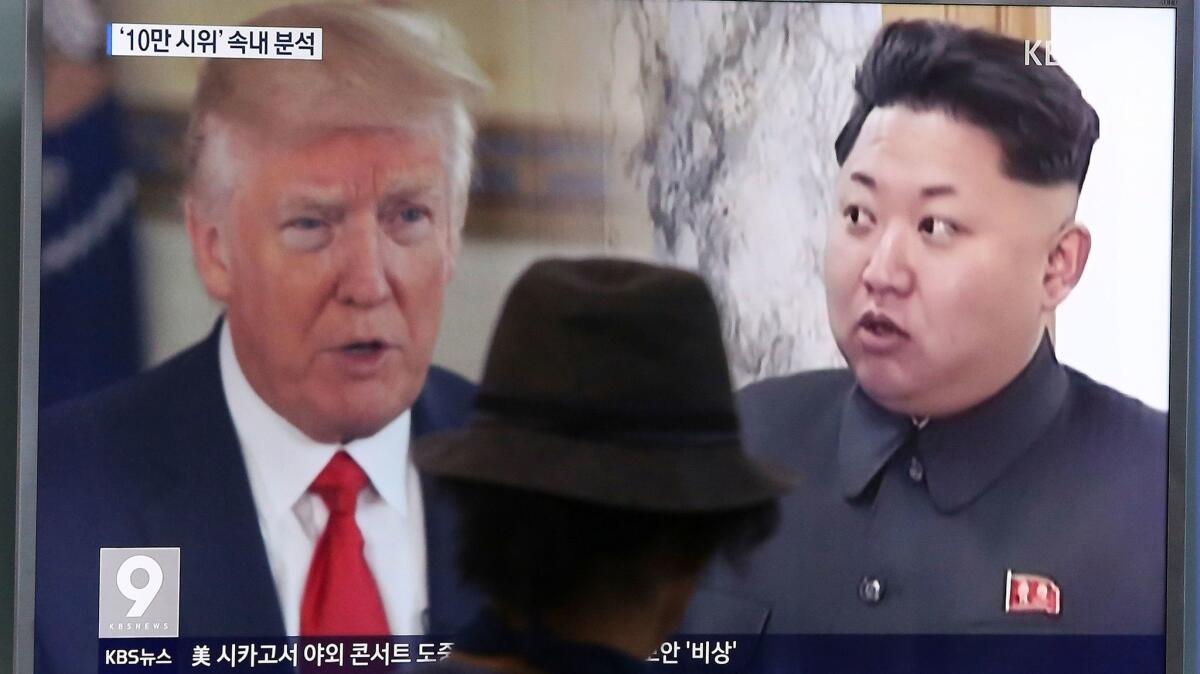 A man watches a television screen showing President Trump and North Korean leader Kim Jong Un during a news program at the Seoul Train Station in Seoul, South Korea on Aug. 10, 2017.