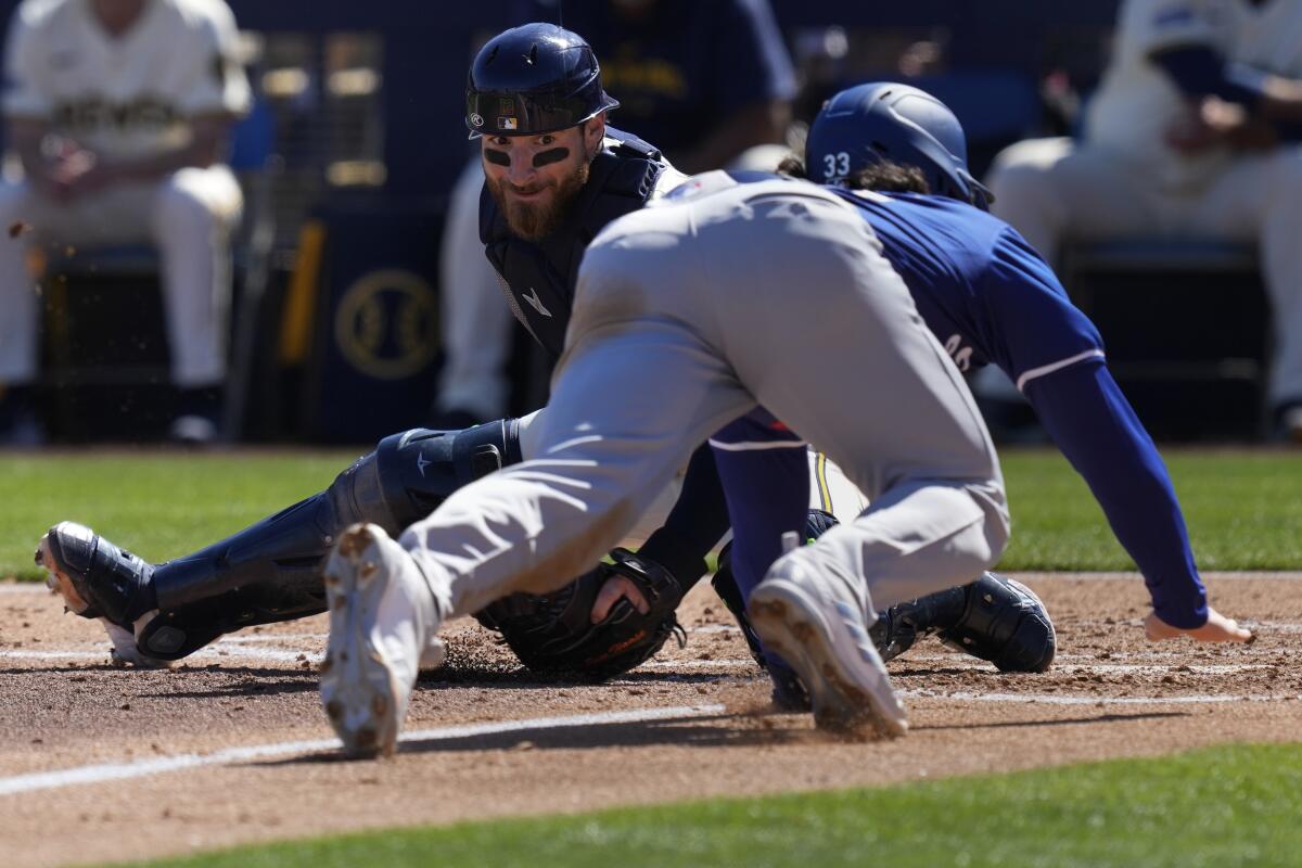 Milwaukee Brewers catcher Eric Haase looks to place the tag as Los Angeles Dodgers' James Outman is caught out stealing home during the third inning of a spring training baseball game, Saturday, March 2, 2024, in Phoenix. (AP Photo/Carolyn Kaster)