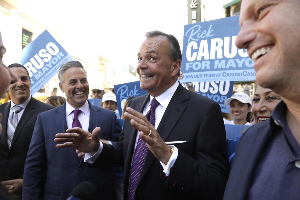Los Angeles City Councilman Joe Buscaino, left, and businessman Rick Caruso surrounded by supporters