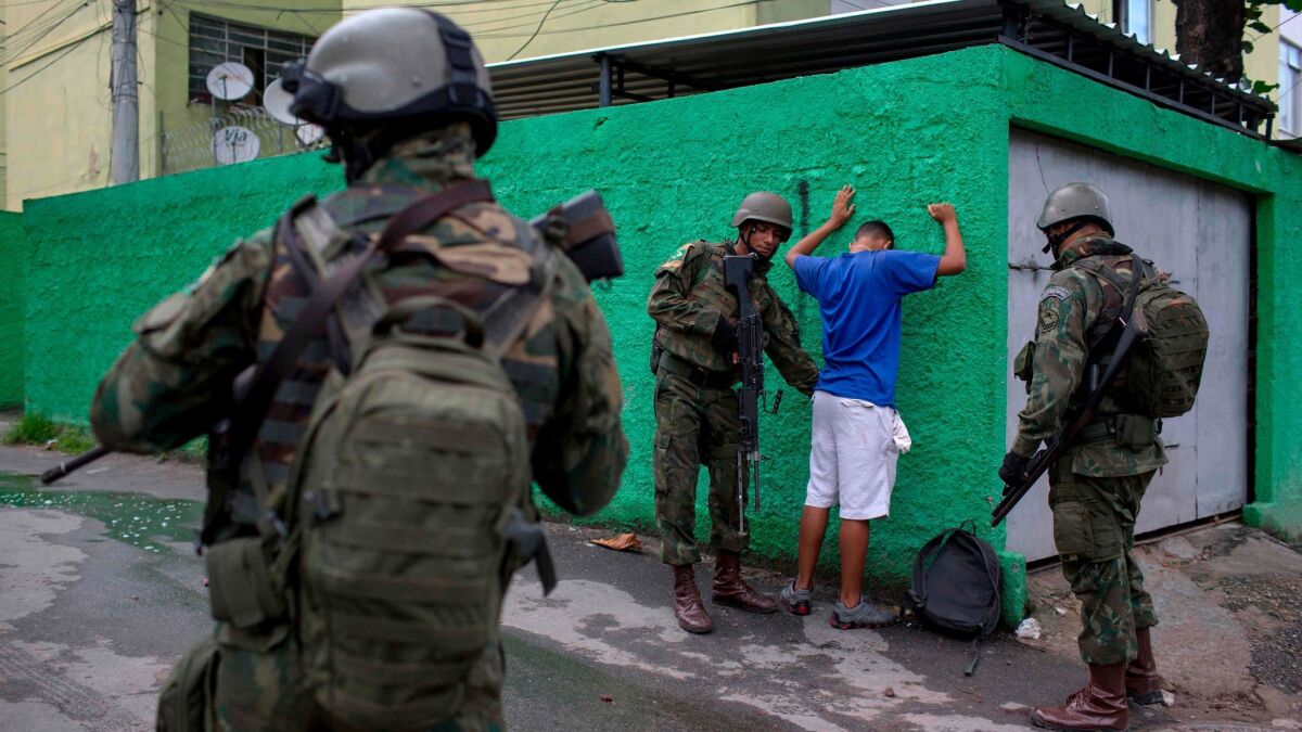 Brazilian soldiers frisk a resident during a joint operation at the Cidade de Deus (City of God) favela in Rio de Janeiro, Brazil, on Feb. 07, 2018.