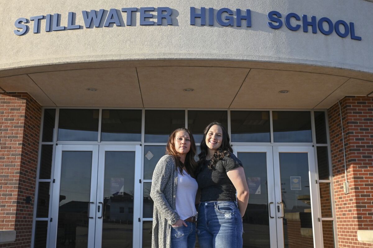 Angela Morgan, left, and her daughter Sidney McLaughlin stand in front of Stillwater High School in Stillwater, Okla., March 15, 2022. Nearly 50 years after Congress passed the sweeping law that guarantees equity in “any education program or activity receiving Federal financial assistance,” including high school athletics, girls are stuck in an imperfect system that continues to favor boys. (Jason Elquist/Elm Tree Photo via AP)