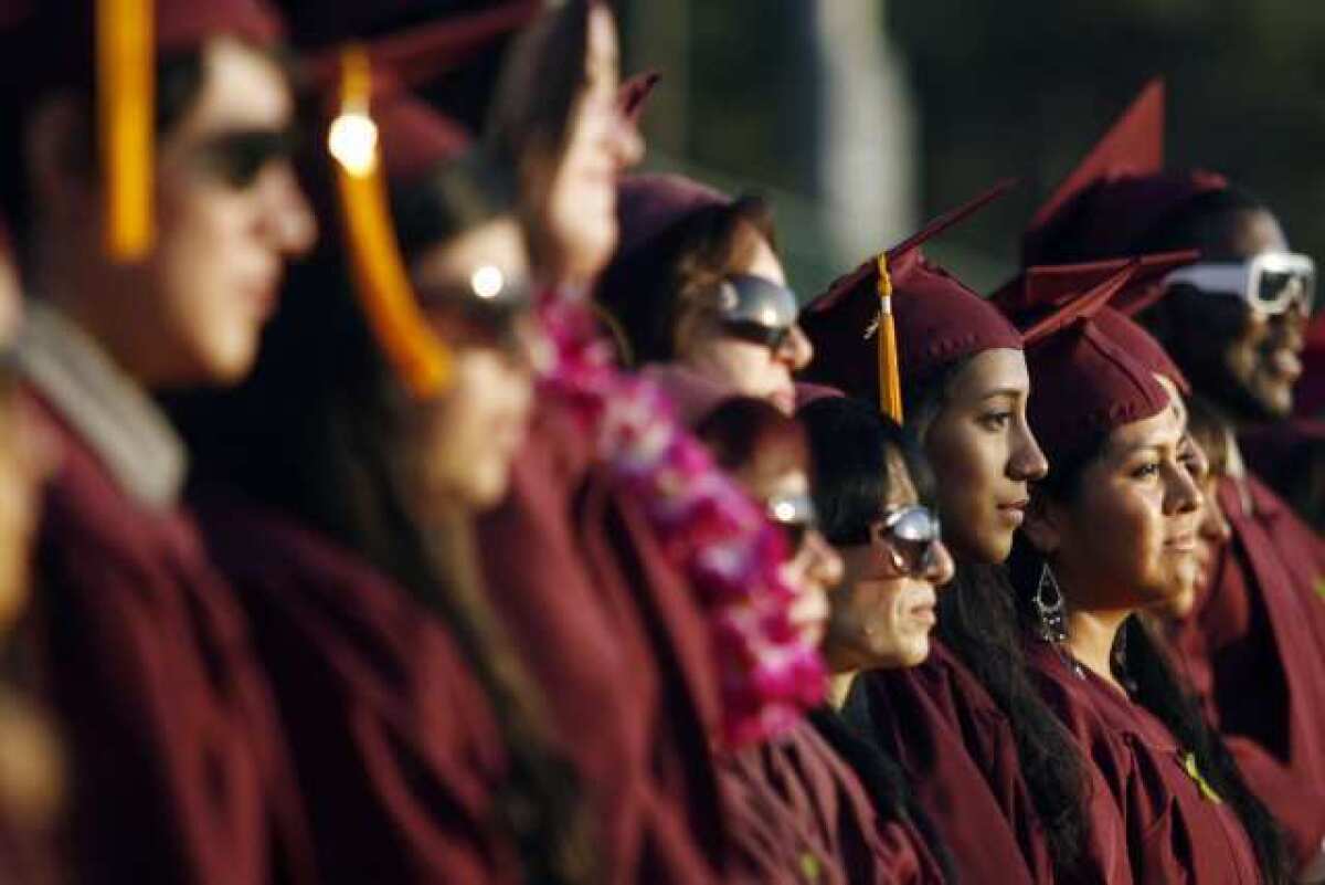 Glendale Community College's Rosenda Colmenares, from third right, and other graduates line up as they listen to the Chambers Singers Men perform during GCC's graduation ceremony in Glendale.