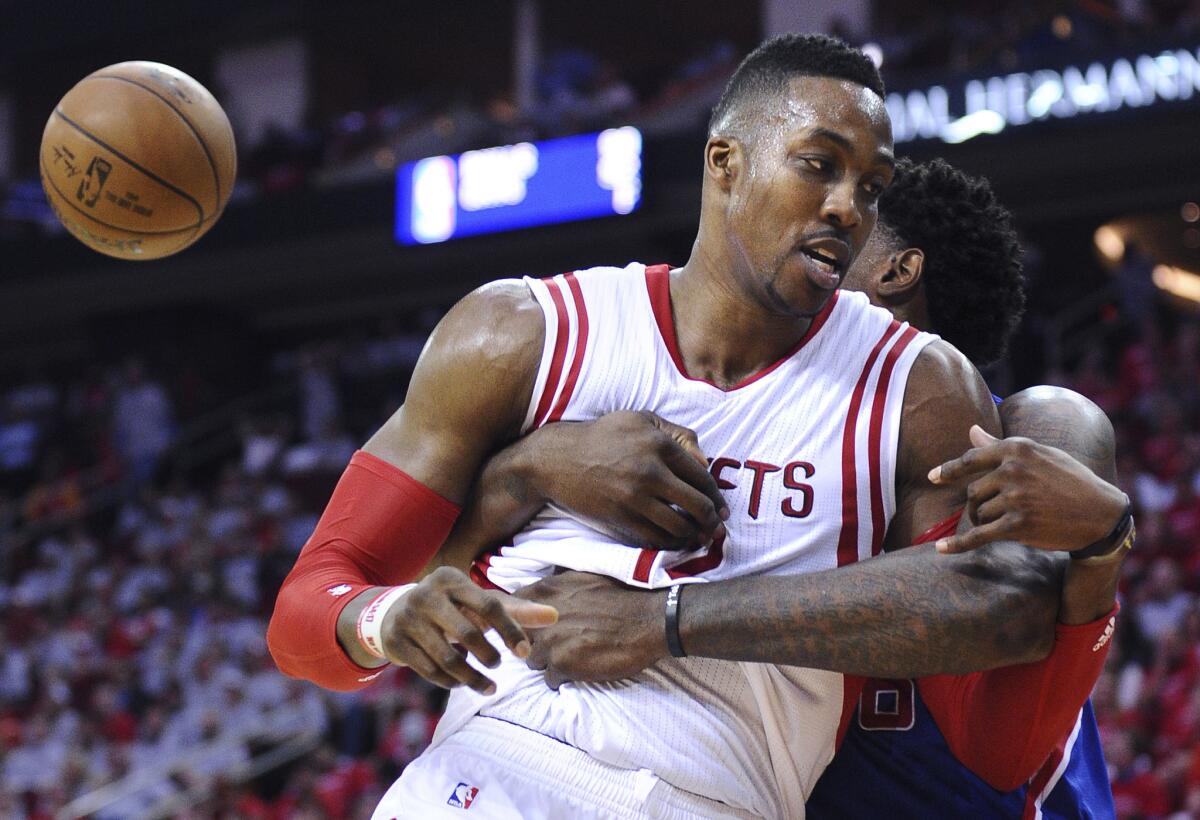 Rockets center Dwight Howard is wrapped up by Clippers center DeAndre Jordan, who was called for an intentional foul, in the fourth quarter of Game 1 of their NBA Western Conference semifinal series. The Clippers won, 117-101.