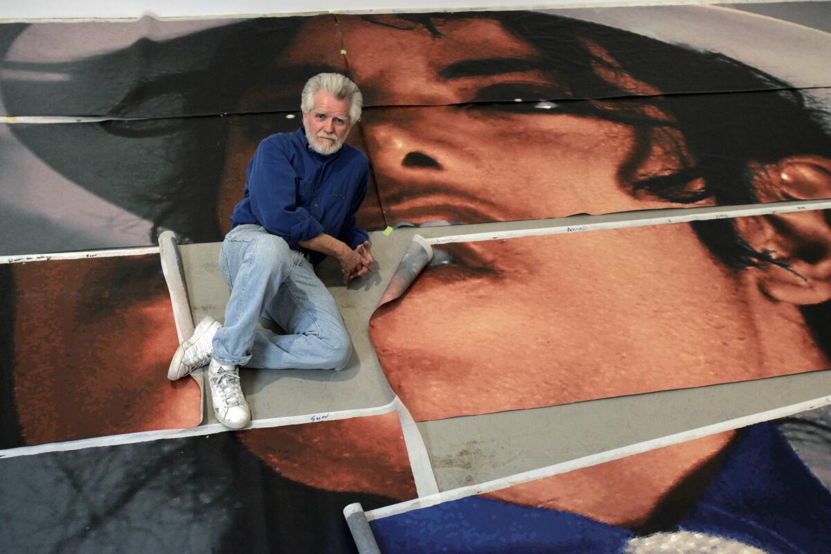 In this 2009 photo, artist Kent Twitchell sits with panels that make up his Michael Jackson mural. The Museum of the San Fernando Valley will debut an exhibit Friday displaying elements of the little-seen 10-story-tall mural.