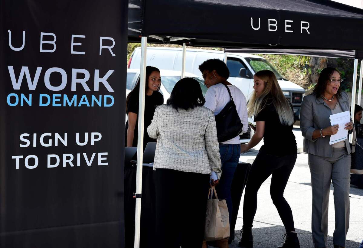 Uber plans to offer bonuses for veteran referrals and expand its ride-hailing service to military bases. Above, an Uber recruitment event in South Los Angeles in March.