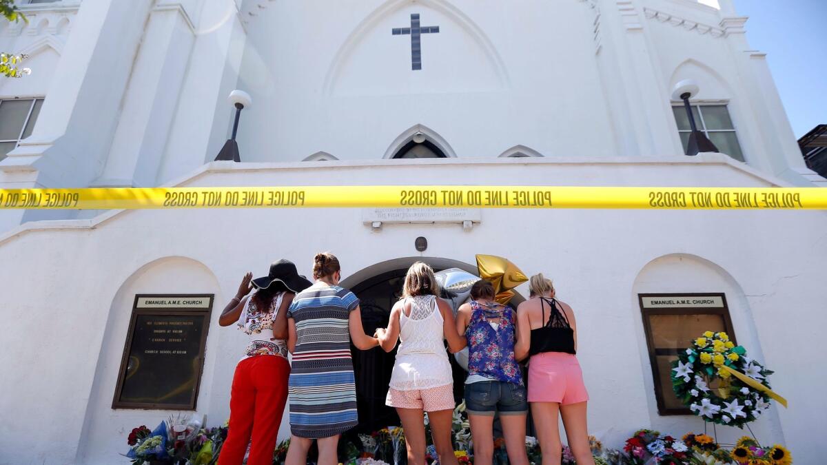 A group of women pray together at a makeshift memorial in front of the Emanuel AME Church, in Charleston, S.C. on June 18, 2015.