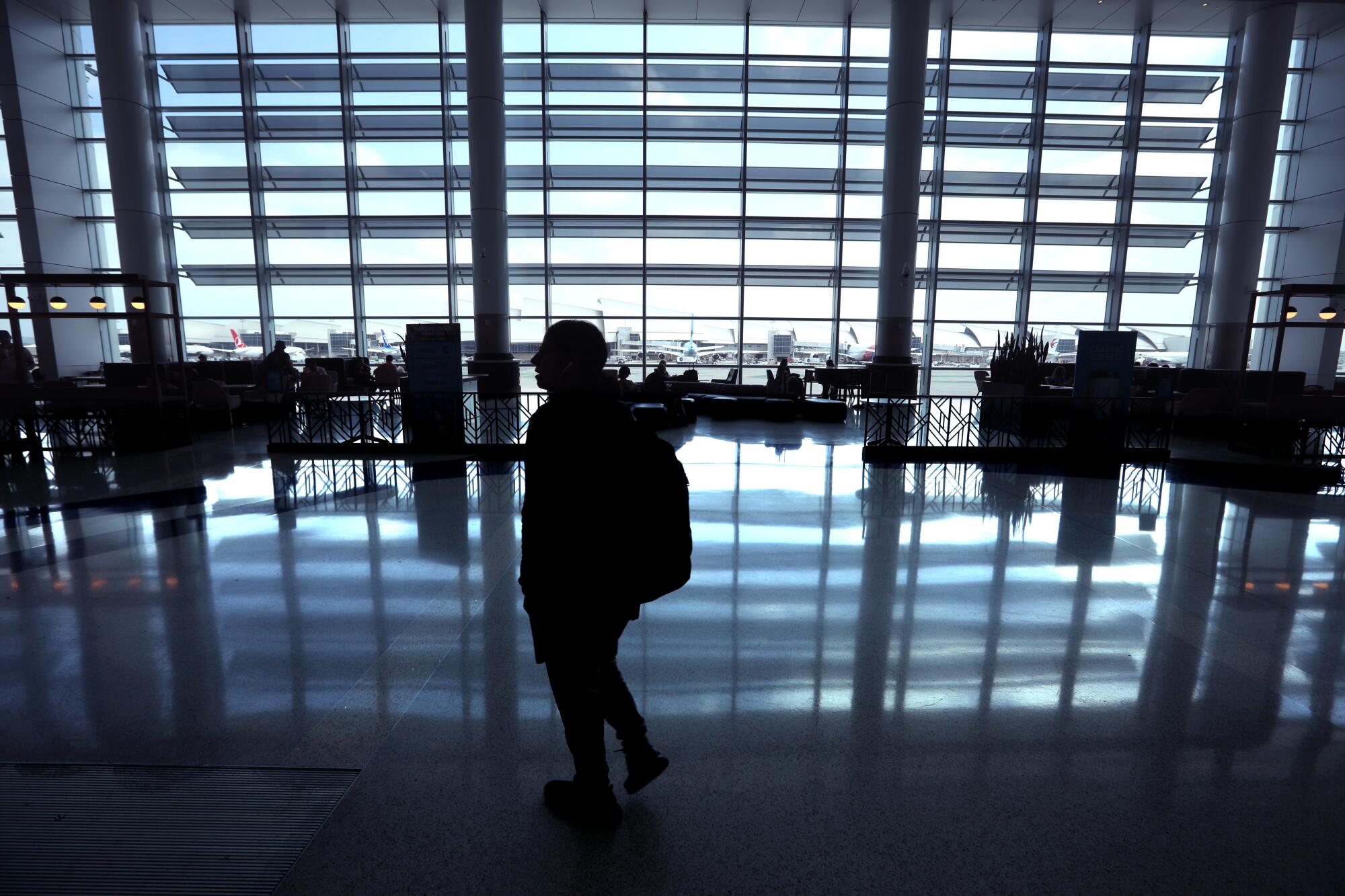 A man silhouetted inside an airport terminal