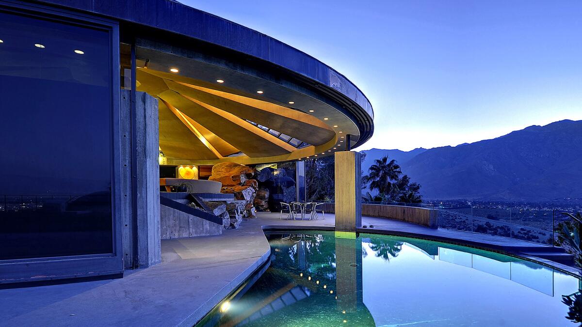 A retractable glass curtain divides the living room and pool terrace.