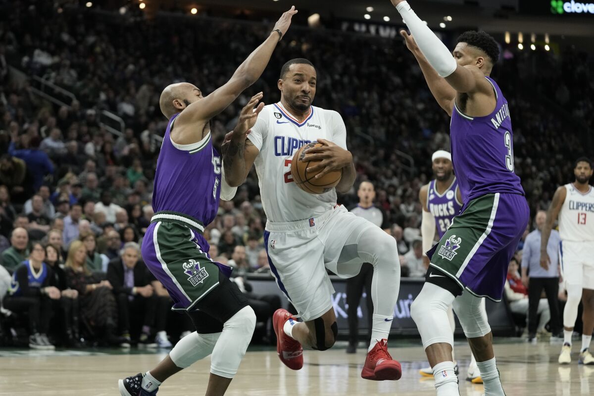 Clippers' Norman Powell drives between Milwaukee Bucks' Jevon Carter and Giannis Antetokounmpo during the second half.