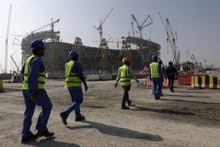 FILE - Workers walk to the Lusail Stadium, one of the 2022 World Cup stadiums, in Lusail, Qatar.