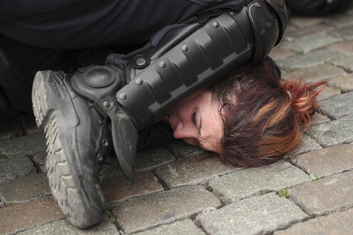 Police pin a woman to the ground during a protest in Brussels in May 2019.