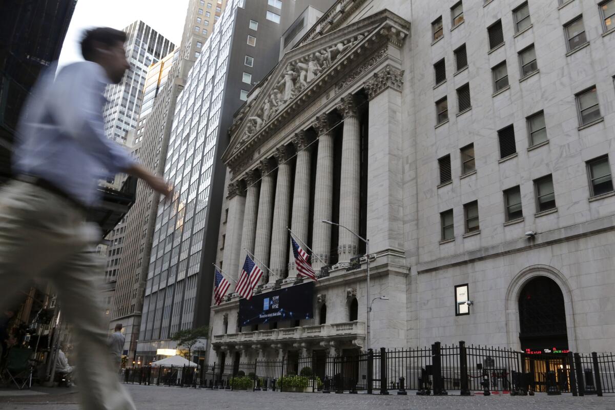 A man walks past the New York Stock Exchange